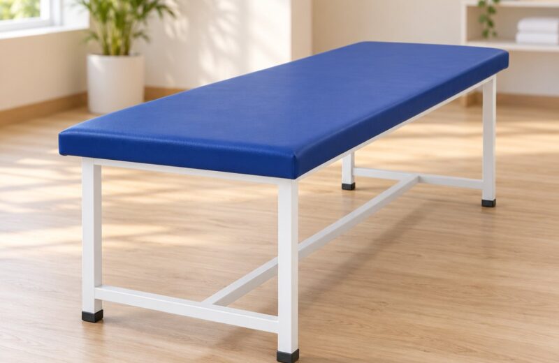 Treatment table with a blue padded top on a white steel frame